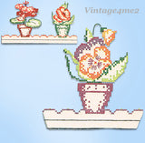 Cross-stitched floral pot plant design on a light blue background with 'Vintage4me2' branding.